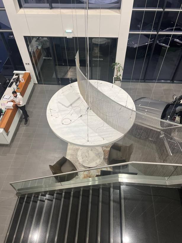 BMW showroom reception desk with chandelier installation from above